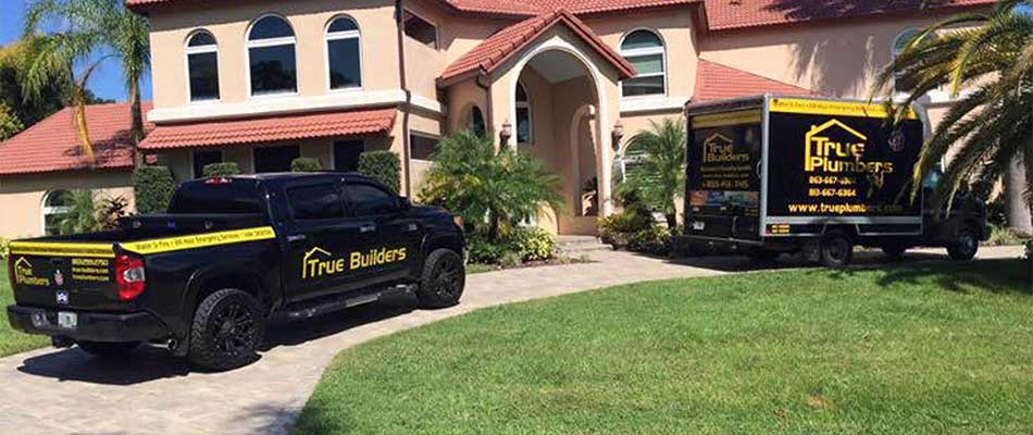 True Plumbers & AC trucks at a home in Lakeland, FL for air conditioning installation services.